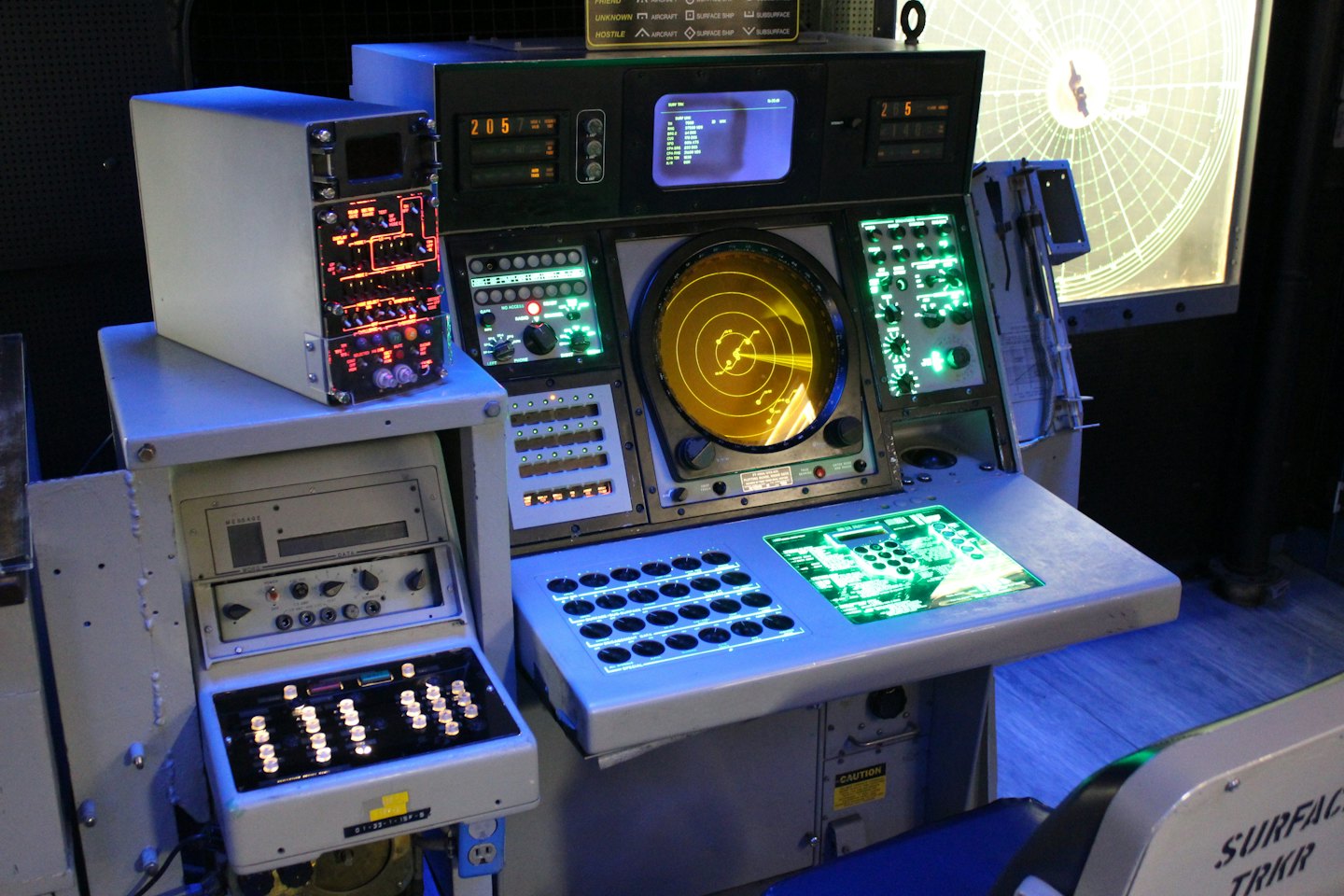 Retro military control console with glowing radar and switches.